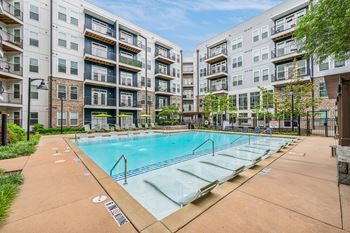 an apartment swimming pool in front of an apartment building